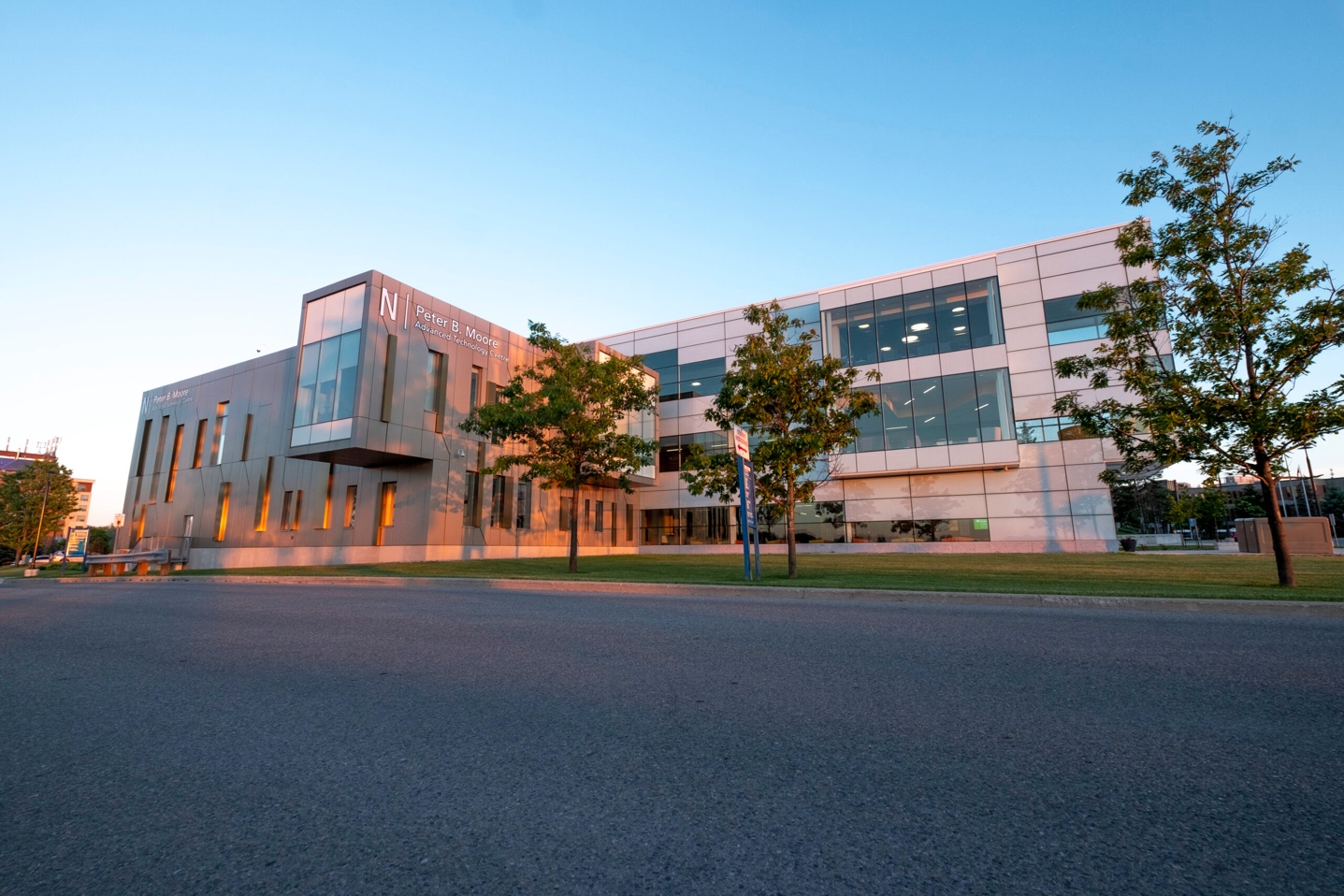 Exterior view at dusk of the Peter B. Moore Advanced Technology Centre at Georgian College, a modern three-storey building with extensive glazing and metal panelling.